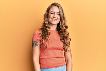 Obraz premium Young blonde girl wearing casual clothes winking looking at the camera with sexy expression, cheerful and happy face.
