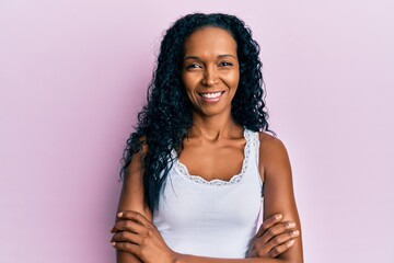 Middle age african american woman wearing casual clothes happy face smiling with crossed arms looking at the camera. positive person.