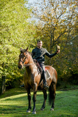 A black horse and a a man on a sunny autumn day.