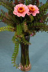 A floral arrangement with pink zinnia flowers and spikes of purple shiso flowers
