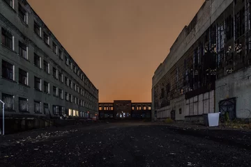 Fotobehang Territory of abandoned industrial area waiting for demolition at night. Broken and burnt buildings © Mulderphoto
