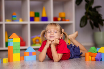 The girl plays with toys at home, in kindergarten or nursery. Child development.
