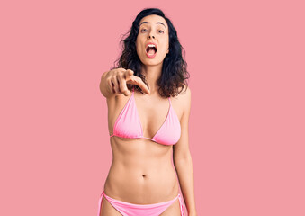 Naklejka premium Young beautiful hispanic woman wearing bikini pointing displeased and frustrated to the camera, angry and furious with you