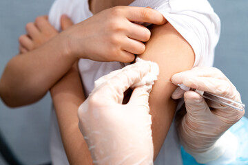 Doctor vaccinating child. Coronavirus vaccination. Covid-19 vaccine at clinic. Little boy getting flu shot. Pediatrician examining kid and giving injection. Virus prevention. Health care.
