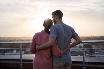 Couple embracing and looking at the sun
