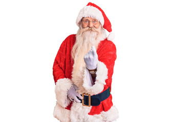 Old senior man with grey hair and long beard wearing traditional santa claus costume beckoning come here gesture with hand inviting welcoming happy and smiling