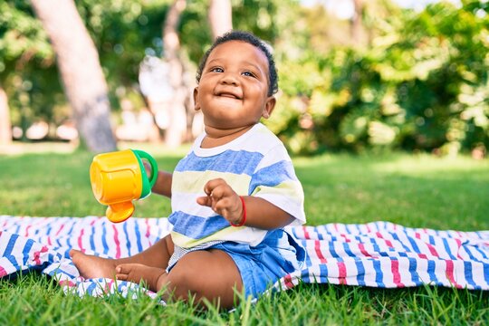 Adorable african american toddler smiling happy playing with toy at the park.