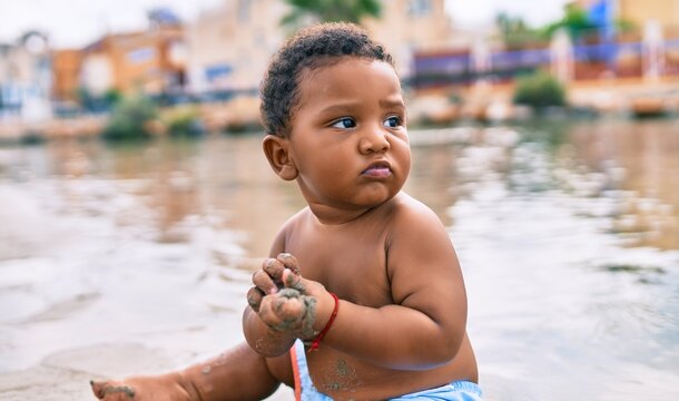 Adorable african american toddler sitting at the beach.