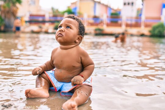 Adorable african american toddler sitting at the beach.