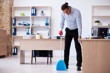 Young male employee cleaning office during pandemic