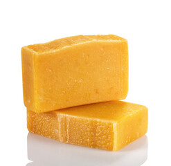 Handmade organic soap from natural products. Two bars of soap with orange and amber powder on a white background.