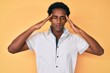 African handsome man wearing casual shirt suffering from headache desperate and stressed because pain and migraine. hands on head.