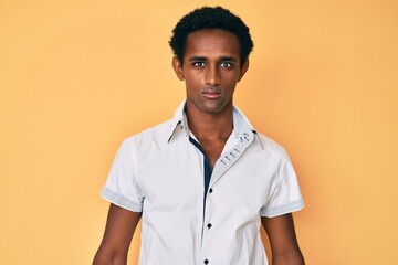 African handsome man wearing casual shirt with serious expression on face. simple and natural looking at the camera.