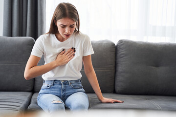 Woman sitting with strong chest pain