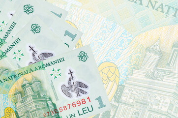 1 Romanian leu bills lies in stack on background of big semi-transparent banknote. Abstract business background