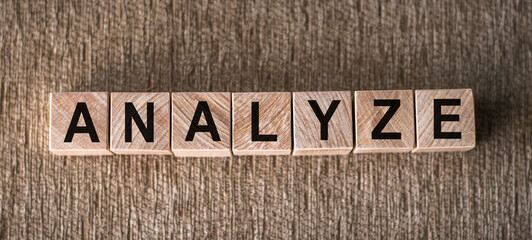 Analyze - word written on wooden blocks over brown background.
