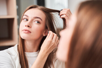 Woman looking at her reflection at the mirror