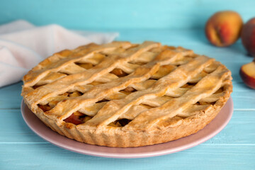 Delicious fresh peach pie on light blue wooden table, closeup