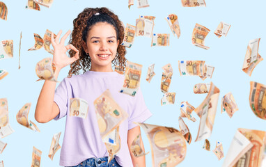 Beautiful kid girl with curly hair wearing casual clothes smiling positive doing ok sign with hand and fingers. successful expression.