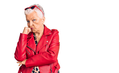 Senior beautiful woman with blue eyes and grey hair wearing a modern style with a red leather...