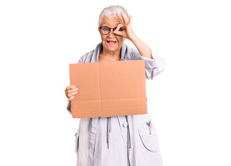 Senior beautiful woman with blue eyes and grey hair holding we need a change banner smiling happy doing ok sign with hand on eye looking through fingers