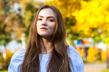 Close up portrait of a young beautiful woman in autumn park