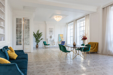 modern and very stylish interior design of large studio apartment with fashionable furniture with gold elements. very light and bright room with big windows