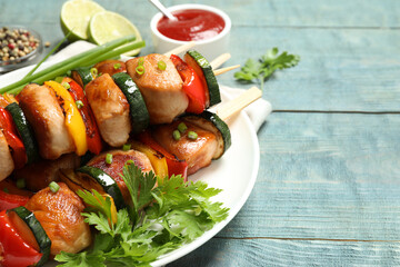 Delicious chicken shish kebabs with vegetables and parsley on light blue wooden table, closeup. Space for text