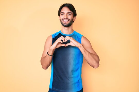 Handsome hispanic man wearing sportswear smiling in love showing heart symbol and shape with hands. romantic concept.