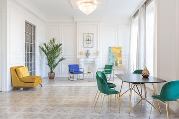 modern and very stylish interior design of large studio apartment with fashionable furniture with gold elements. very light and bright room with big windows