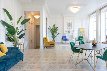 modern and very stylish interior design of large studio apartment with fashionable furniture with gold elements. very light and bright room with big windows
