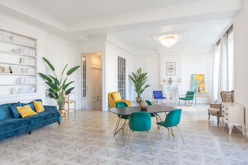 modern and very stylish interior design of large studio apartment with fashionable furniture with gold elements. very light and bright room with big windows