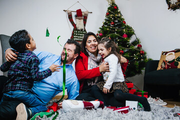 Latin family with kids playing with Santa's toys in Mexico city