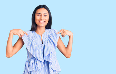 Young beautiful latin girl wearing casual clothes looking confident with smile on face, pointing oneself with fingers proud and happy.