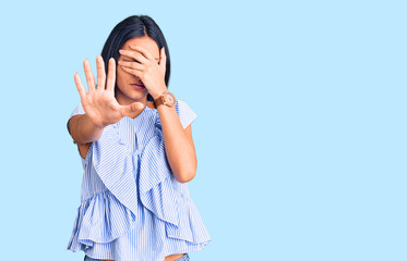 Young beautiful latin girl wearing casual clothes covering eyes with hands and doing stop gesture with sad and fear expression. embarrassed and negative concept.