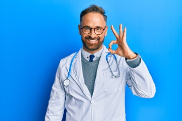 Handsome middle age man wearing doctor uniform and stethoscope smiling positive doing ok sign with...