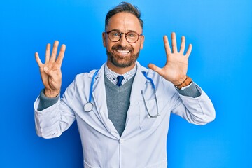 Handsome middle age man wearing doctor uniform and stethoscope showing and pointing up with fingers...