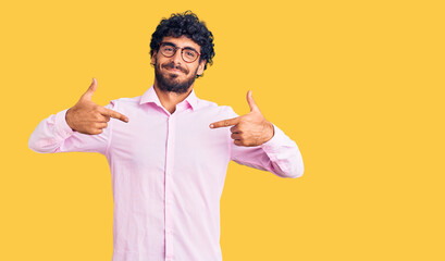 Handsome young man with curly hair and bear wearing business clothes looking confident with smile...