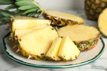 Plate with tasty cut pineapple on table, closeup