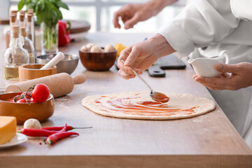 Chefs cooking tasty pizza in kitchen