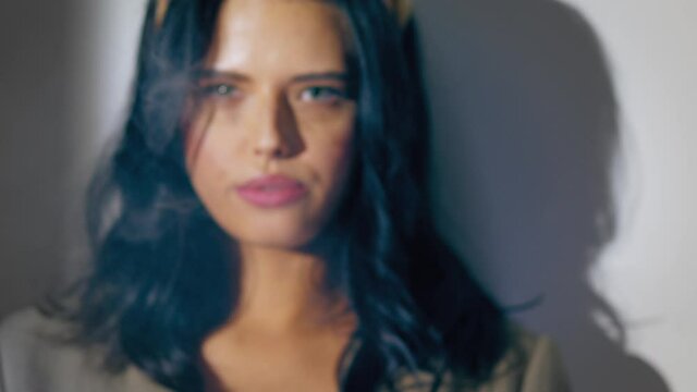 the female languidly exhales smoke from her mouth