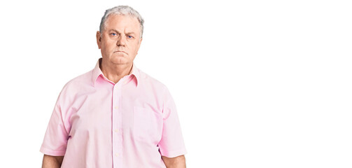 Senior grey-haired man wearing casual clothes with serious expression on face. simple and natural looking at the camera.