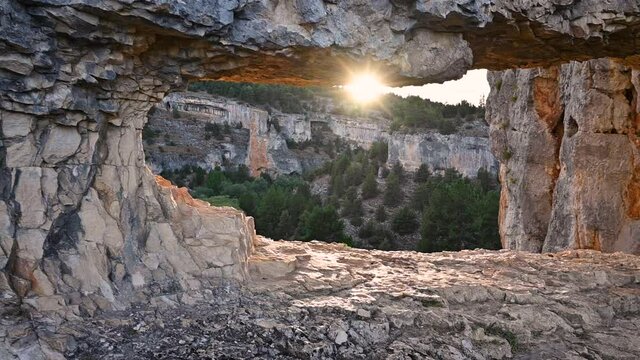 Sun shining through a hole in a scenic rock formation in River wolves canyon, Soria, Spain. High quality 4k footage