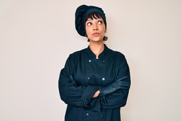 Beautiful brunettte woman wearing professional cook uniform smiling looking to the side and staring away thinking.