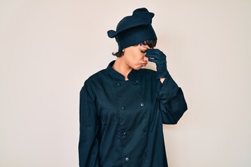 Beautiful brunettte woman wearing professional cook uniform tired rubbing nose and eyes feeling...