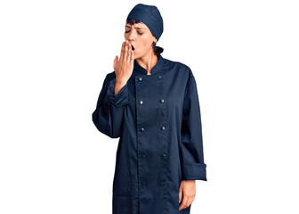 Young brunette woman with short hair wearing professional cook uniform bored yawning tired covering mouth with hand. restless and sleepiness.