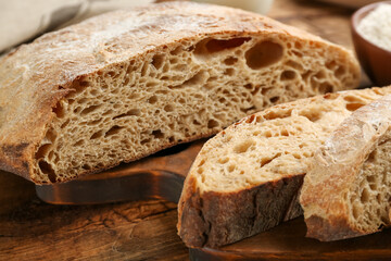 Tasty freshly baked bread on wooden table, closeup