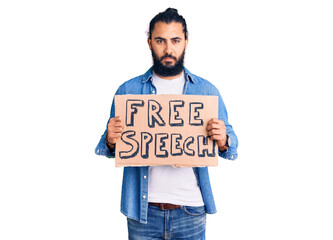 Young arab man holding free speech banner thinking attitude and sober expression looking self confident