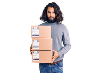 Young arab man holding delivery package thinking attitude and sober expression looking self confident