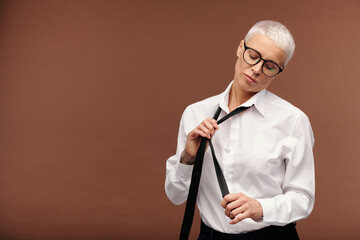 Middle aged female with short dyed blond hair, piercing in nose and tattoos